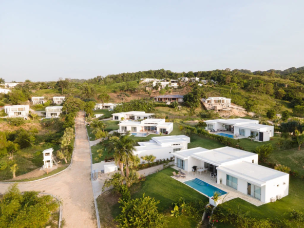 aerial view of white modern villas with pools and landscaping