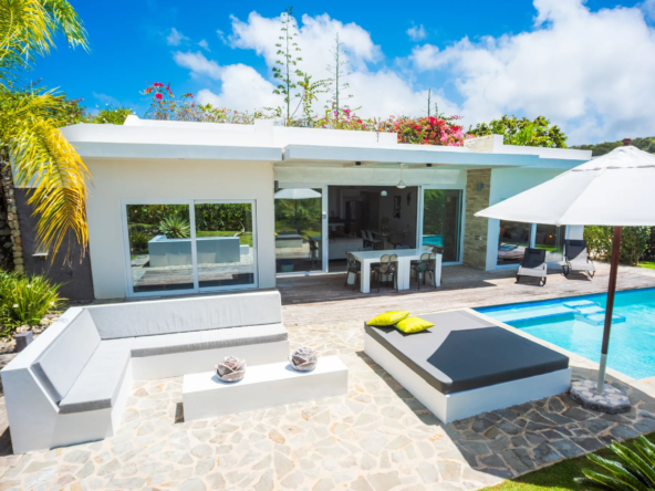 modern villa poolside patio with lounge furniture and sliding doors