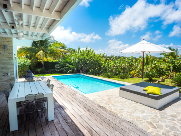 tropical villa pool deck with outdoor dining and lounge area